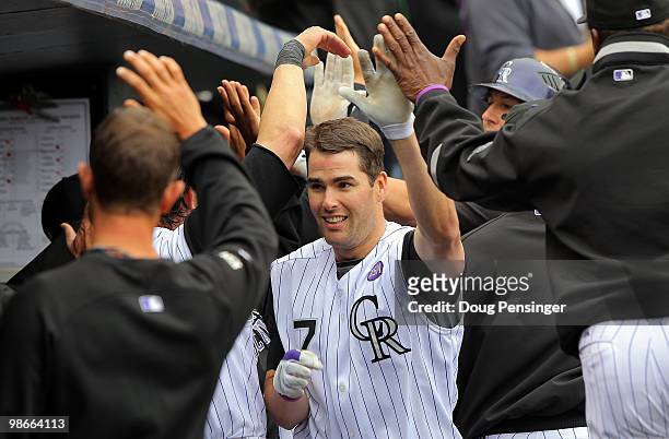 Seth Smith of the Colorado Rockies is welcomed back to the dugout after his three RBI homerun off of starting pitcher Chris Volstad of the Florida...