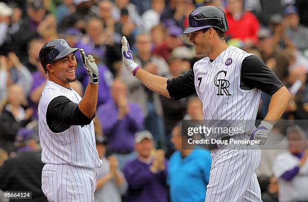 Seth Smith of the Colorado Rockies is welcomed home by catcher Miguel Olivo after his three RBI homerun off of starting pitcher Chris Volstad of the...