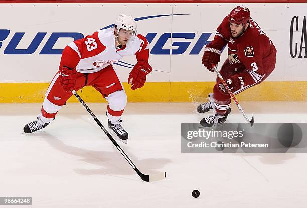 Darren Helm of the Detroit Red Wings skates after a loose puck under pressure from Keith Yandle of the Phoenix Coyotes in Game Five of the Western...
