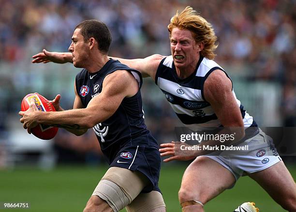 Heath Scotland of the Blues beats the tackle of Cameron Ling of the Cats during the round five AFL match between the Carlton Blues and the Geelong...