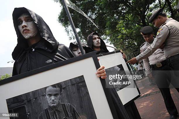 Activists from environmental action group Greenpeace carry portraits of victims from the 1986 Chernobyl nuclear plant disaster during an anti-nuclear...