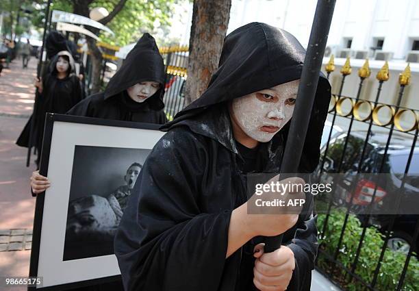 Activists from environmental action group Greenpeace carry portraits of victims from the 1986 Chernobyl nuclear plant disaster during an anti-nuclear...