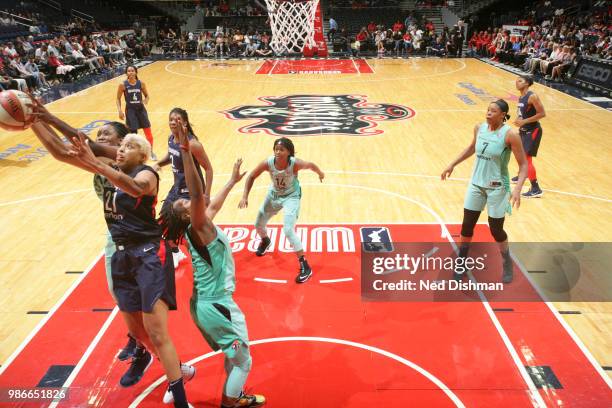 Tianna Hawkins of the Washington Mystics and Tina Charles of the New York Liberty reach for the ball on June 28, 2018 at Capital One Arena in...