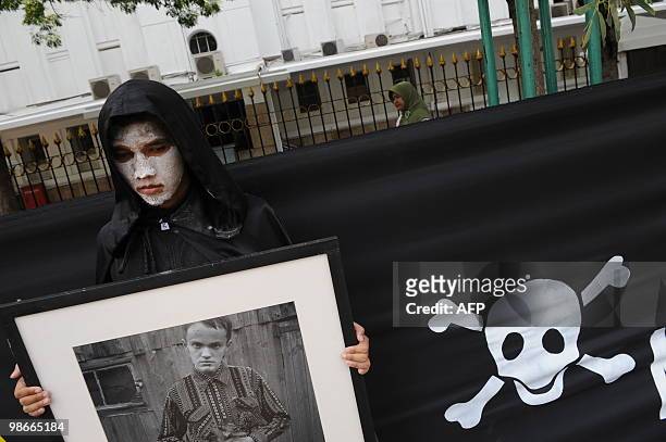 An activist from environmental action group Greenpeace holds a portrait of a victim from the 1986 Chernobyl nuclear plant disaster during an...