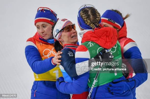 Ragnhild Haga , Marit Bjoergen, Astrid Uhrenholdt Jacobsen and Ingvild Flugstad Oestberg from Norway at the finish line celebrating their gold medal...