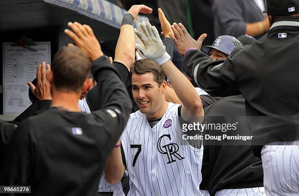 Seth Smith of the Colorado Rockies is welcomed back to the dugout after his second homerun against the Florida Marlins at Coors Field on April 25,...