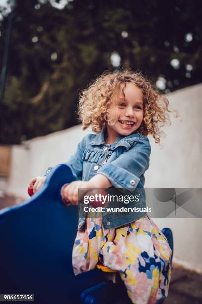 adorable jeune fille aux cheveux blonds bouclé, jouant au terrain de jeux de parc - hair curls photos et images de collection
