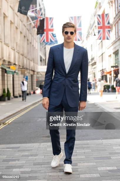 Model Toby Huntingdon Whiteley wears a Lutwyche suit, Kurt Keiger shoes and Monokel sunglasses during London Fashion Week Men's on June 9, 2018 in...