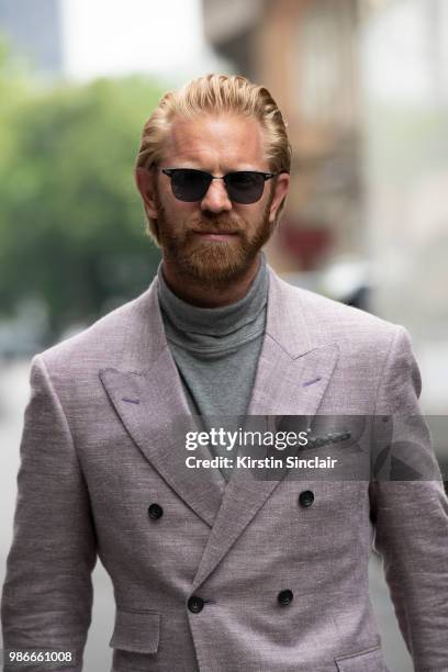 Photographer Alistair Guy wears an English Cut suit, Oliver Peoples sunglasses, Clements and Church roll neck sweater during London Fashion Week...