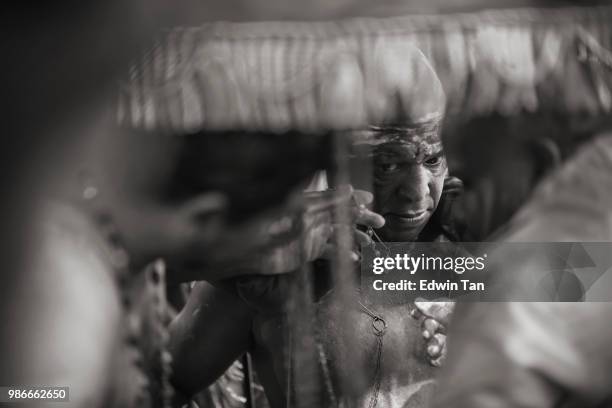 a black and white image  of a male hindu indian prayer getting himself pierced and ready for the worshiping during thaipusam in malaysia - traditional piercings stock pictures, royalty-free photos & images