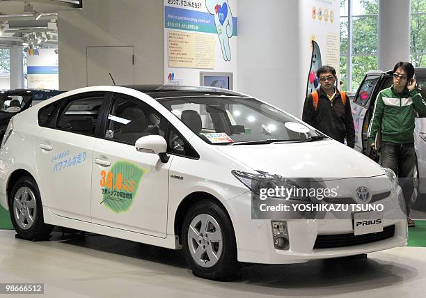 Customers inspect Toyota Motor's hybrid Prius vehicle at the company's showroom in Tokyo on April 26, 2010. Crisis-hit automaker Toyota said that...