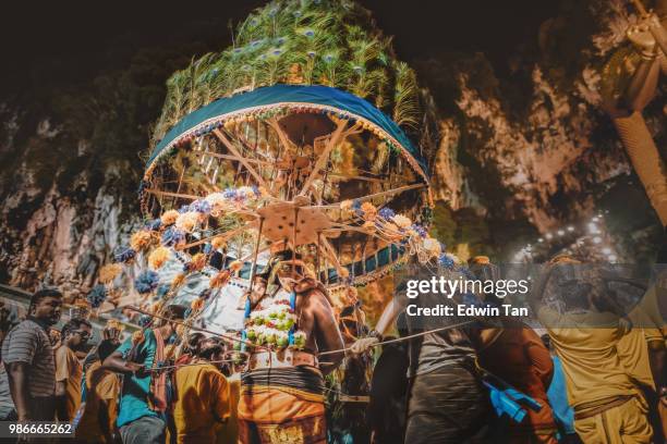 one of the hindu male prayer pierced himself and carry the religious equipment heading toward batu cave temple during the night of thaipusam in malaysia - traditional piercings stock pictures, royalty-free photos & images