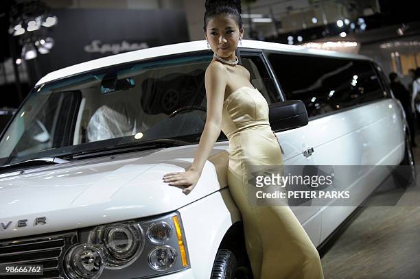 Model poses next to a Range Rover stretch limousine at the Beijing Auto Show near the capital's airport on April 26, 2010. Luxury car sales in China...