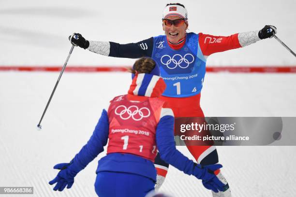 Marit Bjoergen from Norway celebrating at the finish line and being received by teammate Ingvild Flugstad Oestberg during the women's 4x5km...