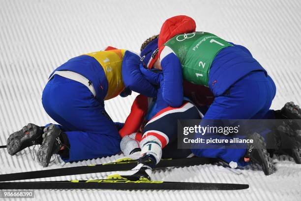 Marit Bjoergen from Norway being greeted at the finish line by teammates Ingvild Flugstad Oestberg and Astrid Uhrenholdt Jacobsen during the women's...