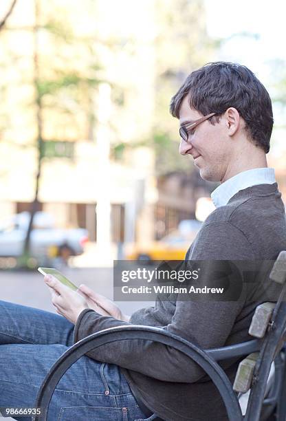 designer reading e-reader in park - e reader 個照片及圖片檔