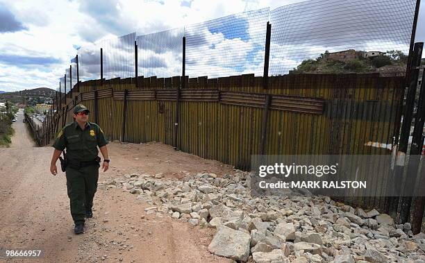 Border Patrol officer keeps watch over the border fence that divides the US from Mexico in the town of Nogales, Arizona on April 23, 2010. Two...