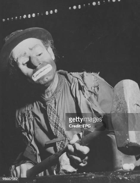 American circus clown Weary Willie, aka Emmett Kelly uses a sledgehammer to crack a nut at the Ringling Brothers and Barnum and Bailey Circus,...