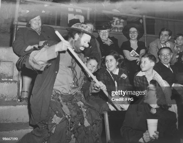 American circus clown Weary Willie, aka Emmett Kelly mingles with the audience to sweep out peanut shells at the Ringling Brothers and Barnum and...
