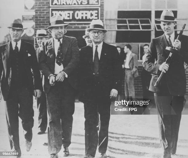 American gangster George Kelly Barnes , aka Machine Gun Kelly, is led away in handcuffs by FBI Agents after his arrest, September 1933. Kelly was...