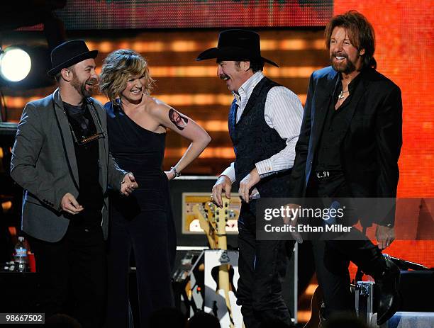 Kristian Bush and Jennifer Nettles of the band Sugarland greet Kix Brooks and Ronnie Dunn of the duo Brooks & Dunn as Nettles shows off a temporary...