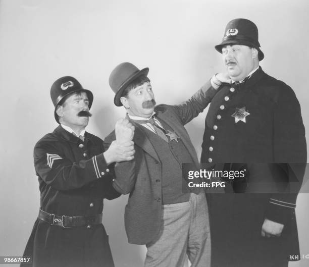 House detective in an altercation with police officers in a publicity still for one of Mack Sennett's 'Keystone Kops' series of silent film comedies,...