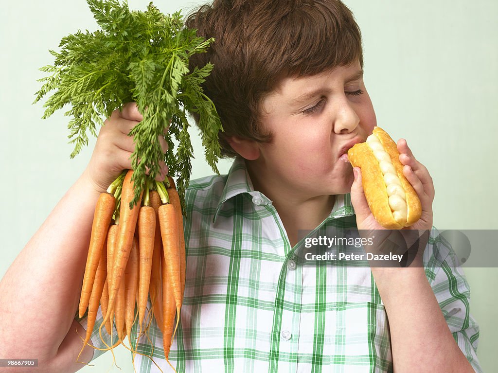 Boy choosing junk food over vegetable