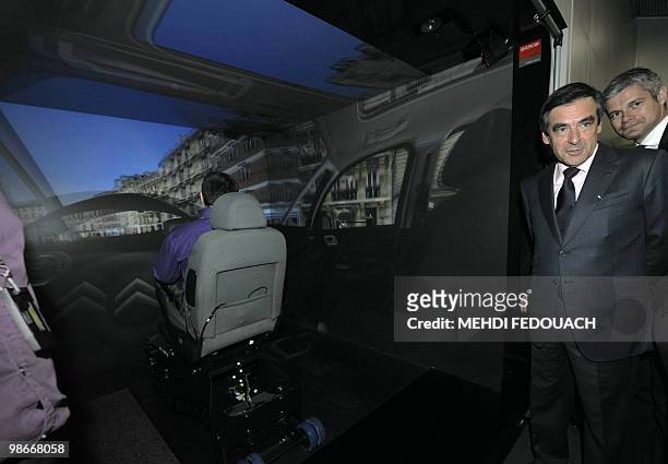 France's Prime Minister Francois Fillon and Junior minister for Employment Laurent Wauquiez visits the virtual reality center at the French auto...