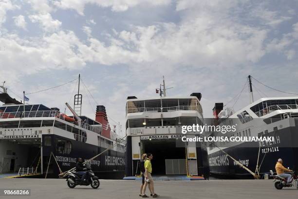 Tourists walk by moored ferries at the port of Piraeus near Athens on April 26, 2010 as seamen stage a 24-hour strike to protest government plans to...