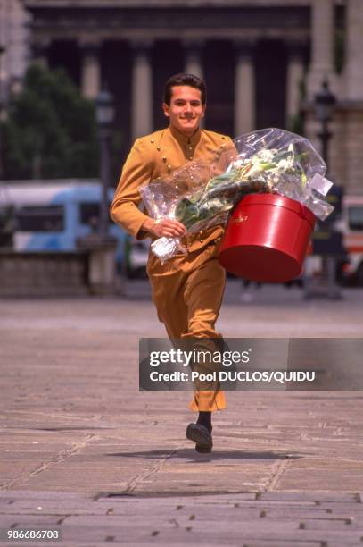 Un groom du Crillon court en tranportant un bouquet de fleurs et un carton à chapeau à Paris le 6 juin 1989, France.