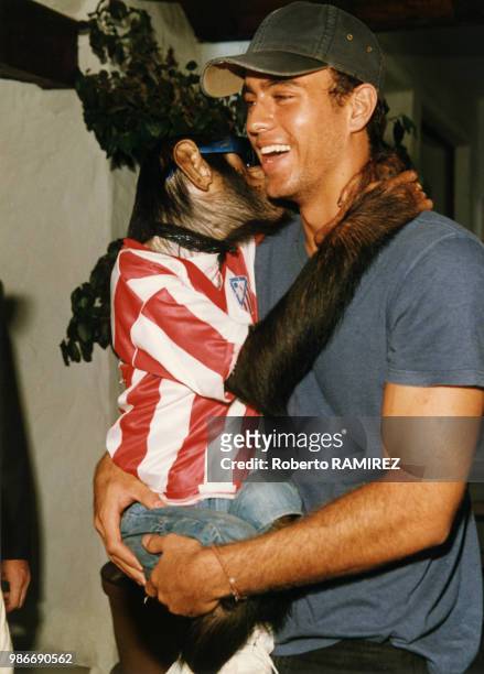 Enrique Iglesias avec un chimpanzé portant un maillot de l'équipe de foot de l'Atlético de Madrid le 16 aout 1997, Madrid, Espagne.