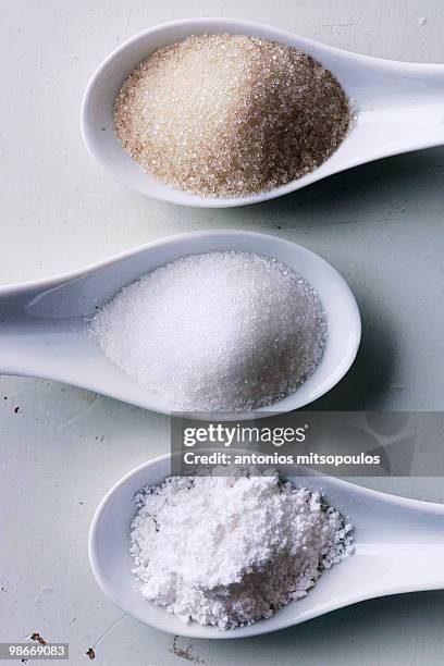 sugar in spoons  - sugar spoon stock pictures, royalty-free photos & images