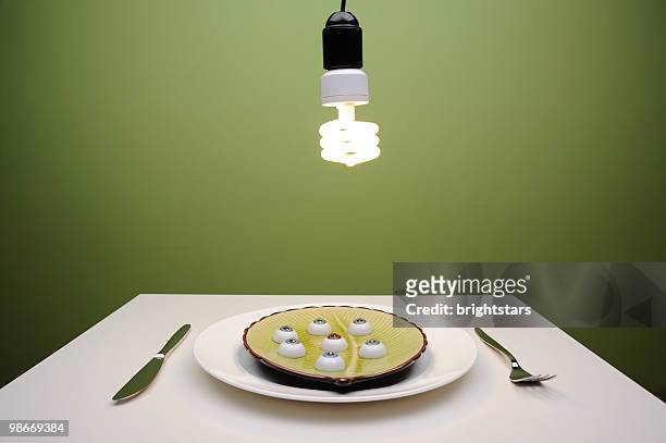 light bulb over a plate - occhio di vetro foto e immagini stock