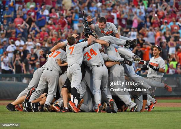 Oregon State Beavers players leap into a dog pile celebrating after defeating the Arkansas Razorbacks for the National Championship during the...