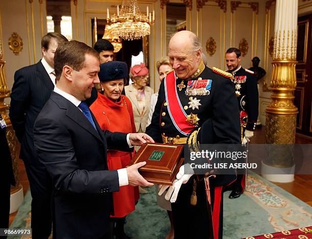 Norwegian King Harald and Russian President Dmitry Medvedev chat as Dmitry Medvedev offers him a box with a carved mammoth tooth at the Norwegian...