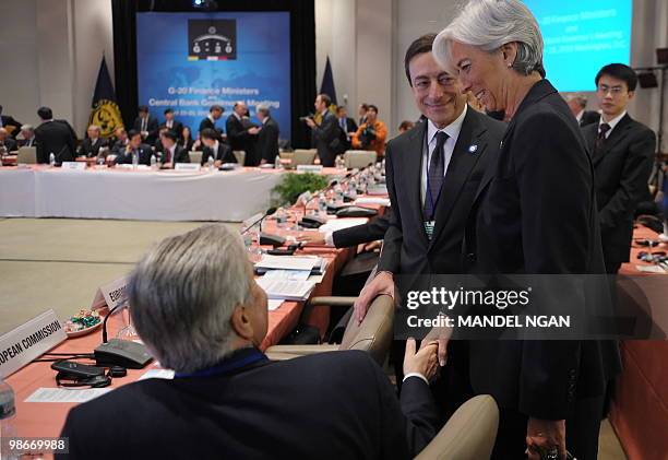 France's Finance Minister Christine Lagarde shakes hands with European Central Bank Jean-Claude Trichet as Banca d'Italia Governor Mario Draghi looks...