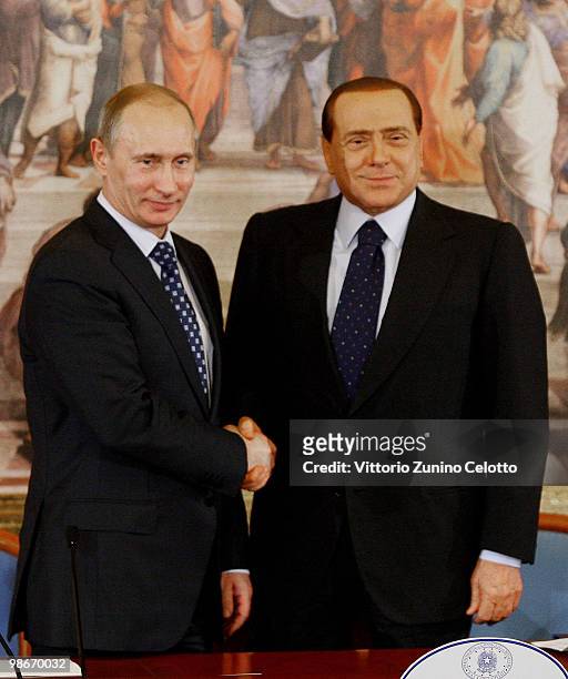 Russian Prime Minister Vladimir Putin shakes hands with Italian Prime Minister Silvio Berlusconi after a press conference at Villa Gernetto on April...