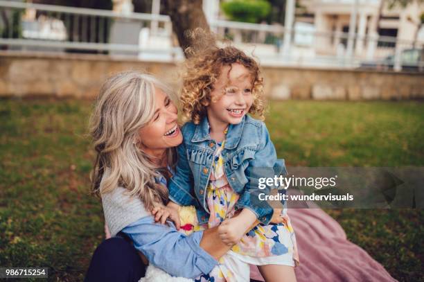 liefdevol oma en kleindochter spelen en lachen samen in tuin - multi generation family outdoor stockfoto's en -beelden