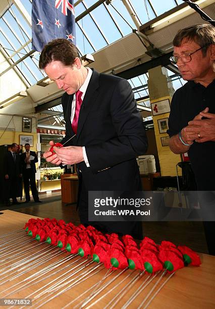 Liberal Democrat leader Nick Clegg inspects a poppy as he speaks to Arthur Dyke during an election campaign visit to the Lady Haig Poppy Factory on...