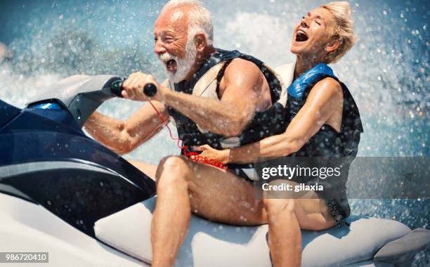 älteres paar jet-ski. - old couple on holiday stock-fotos und bilder