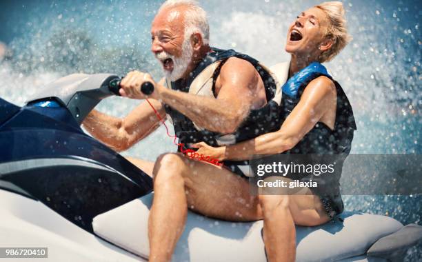senior couple jet skiing. - colete-salva-vidas imagens e fotografias de stock