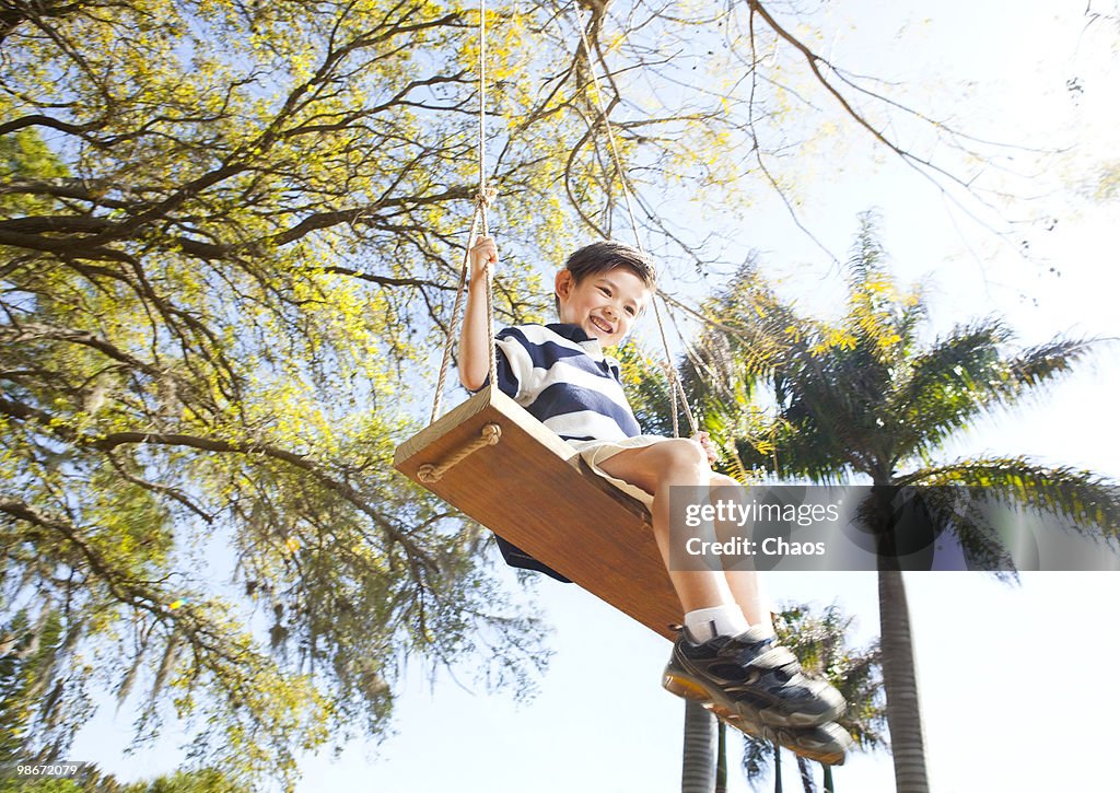 Boy sitting on a hand crafted wood swing