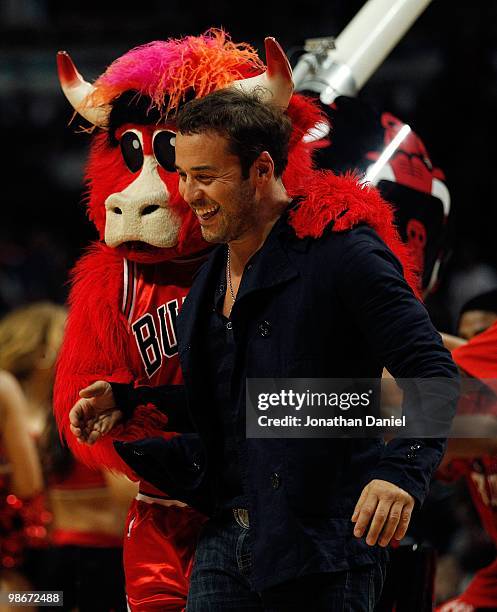 Actor Jeremy Piven jokes with "Benny the Bull," the mascot of the Chicago Bulls, during a time out between the Bulls and the Cleveland Cavaliers in...