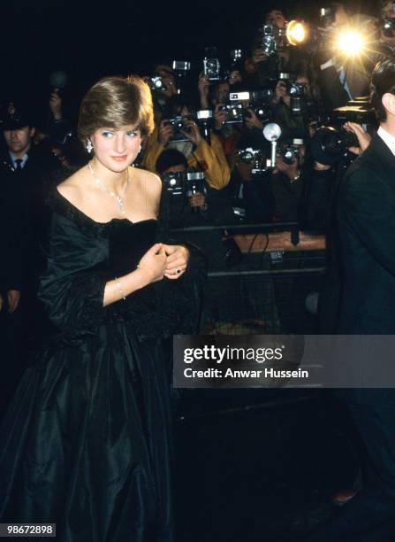 Lady Diana Spencer, wearing a strapless black taffeta dress designed by David and Elizabeth Emanuel, attends a fundraising concert and reception at...