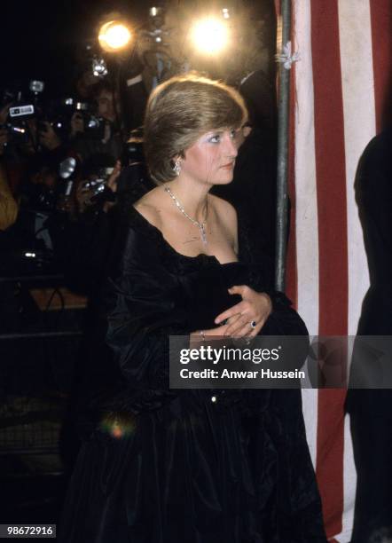 Lady Diana Spencer, wearing a strapless black taffeta dress designed by David and Elizabeth Emanuel, attends a fundraising concert and reception at...