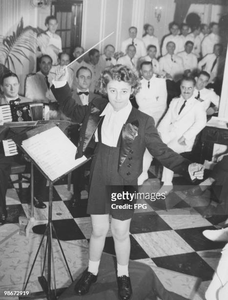 Italian conductor and child prodigy Ferruccio Burco conducts the orchestra on board the liner 'SS Atlantic', 12th December 1951.