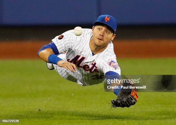 Michael Conforto of the New York Mets dives for a sinking line drive in centerfield in an MLB baseball game against the Los Angeles Dodgers on June...
