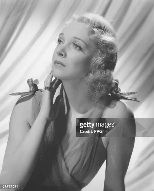 American actress and singer Virginia Bruce wearing a dress with two jewelled birds on the shoulders, circa 1935.