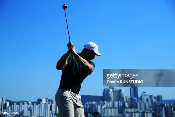 man swinging golf club - adventure club stockfoto's en -beelden