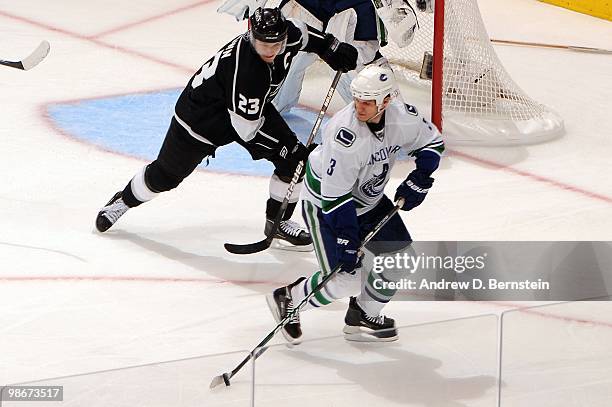 Kevin Bieksa of the Vancouver Canucks skates with the puck against Dustin Brown of the Los Angeles Kings in Game Four of the Western Conference...